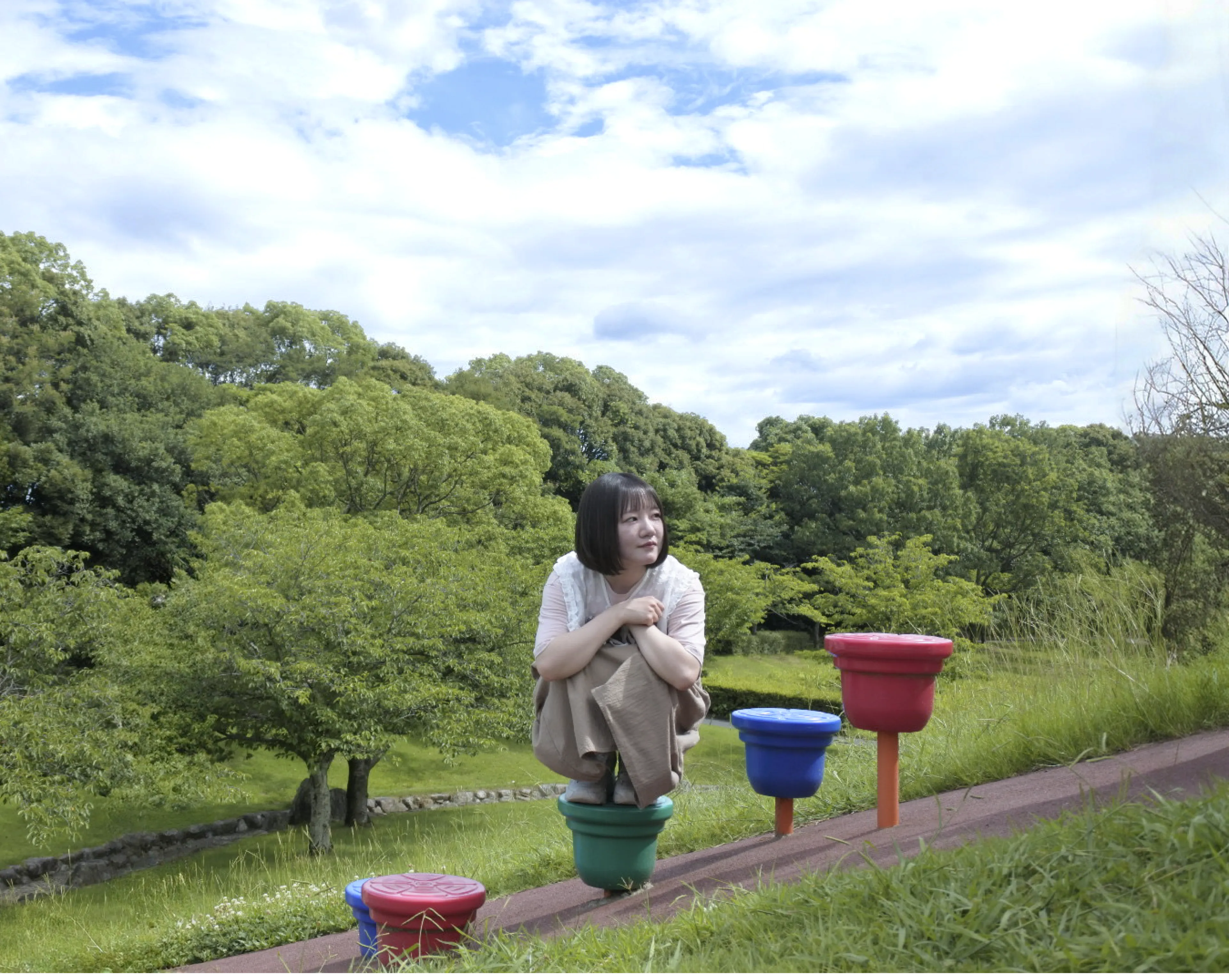 荻島詩央里が3つ並んだ遊具に座っている写真